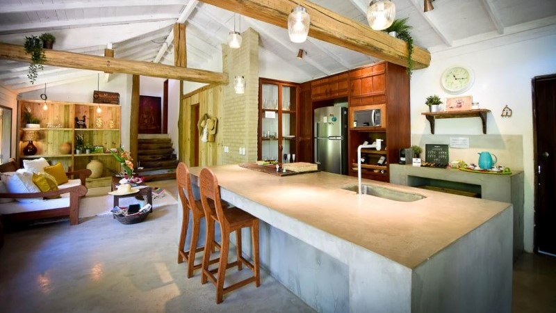 Interior de casa de alto padrão em Trancoso com integração entre sala e cozinha